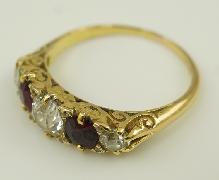 A late Victorian 18ct gold, two stone ruby and three stone diamond set half hoop ring